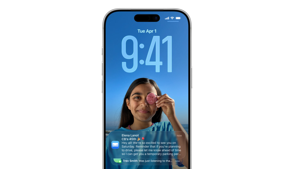Layar Terkunci iPhone dengan foto, angka untuk waktu di Liquid Glass, dua pemberitahuan muncul di bagian bawah layar