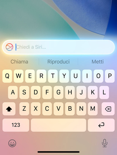 Un campo di testo sopra la tastiera video di un iPhone con la scritta: Chiedi a Siri
