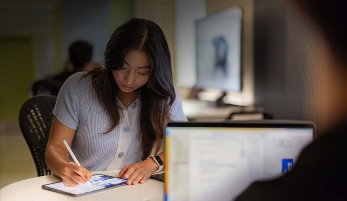 Student die met Apple Pencil notities maakt op een iPad in een technologielab